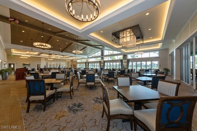 dining area featuring wood finished floors, a high ceiling, a tray ceiling, a chandelier, and recessed lighting