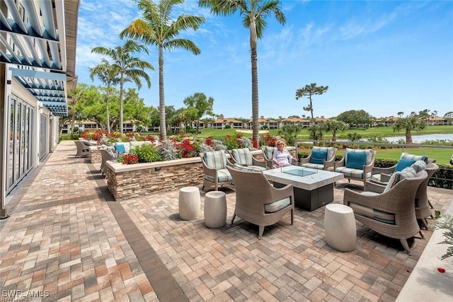 view of patio with a fire pit and a water view