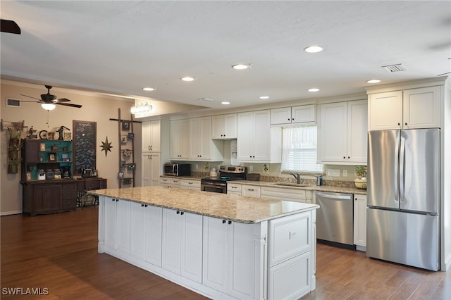 kitchen featuring white cabinets, a kitchen island, sink, and stainless steel appliances