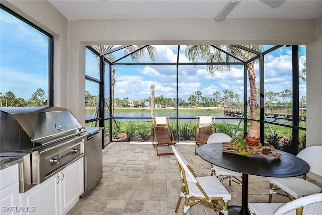 sunroom / solarium featuring a water view