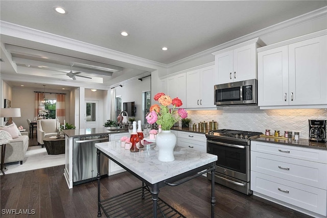 kitchen with crown molding, white cabinetry, backsplash, and appliances with stainless steel finishes