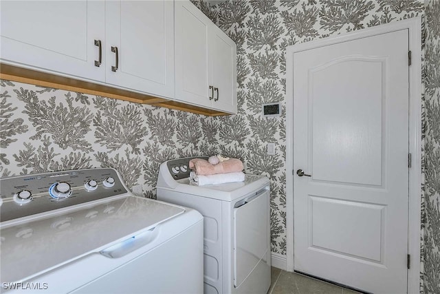 laundry area featuring tile patterned floors, separate washer and dryer, and cabinets