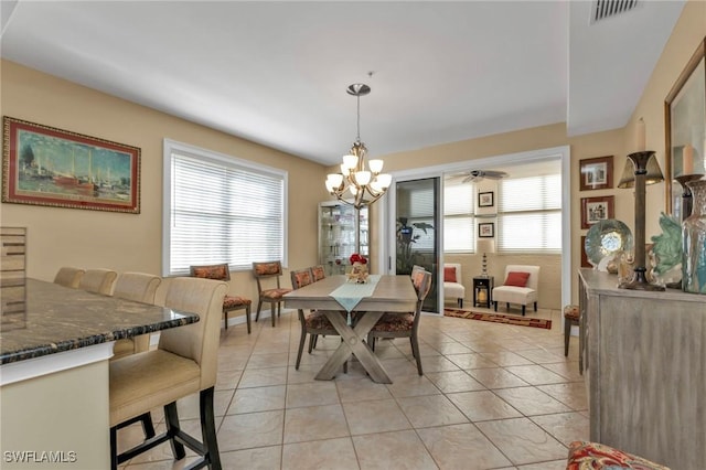 tiled dining room with a notable chandelier