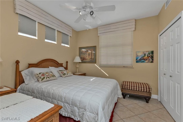 bedroom featuring light tile patterned flooring, a closet, and ceiling fan