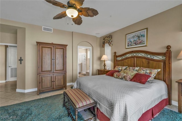 tiled bedroom featuring ensuite bath and ceiling fan