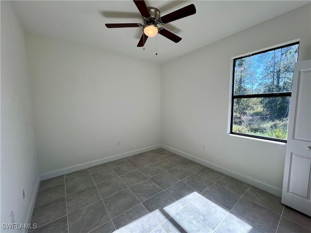 tiled empty room featuring ceiling fan