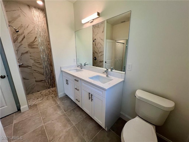 bathroom with tile patterned floors, vanity, toilet, and tiled shower