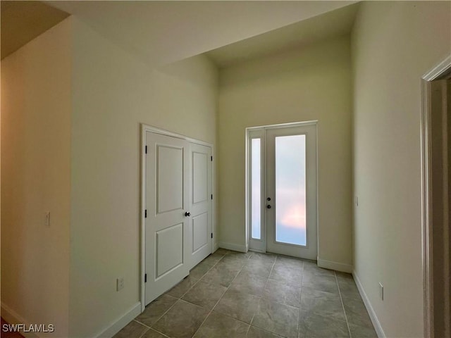 tiled foyer featuring a towering ceiling