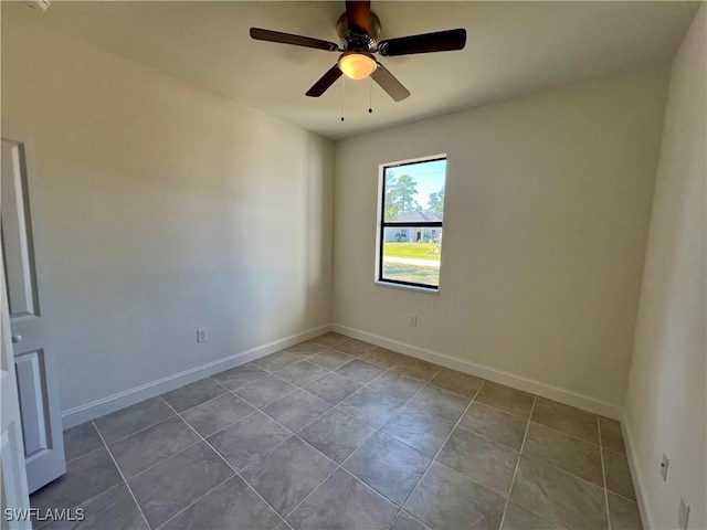 tiled empty room featuring ceiling fan