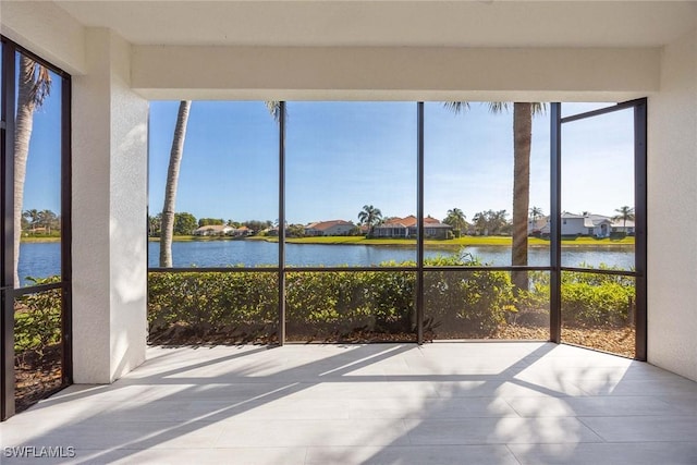 unfurnished sunroom featuring a water view