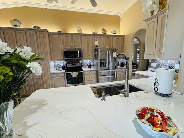 kitchen with stainless steel appliances, a sink, backsplash, light stone countertops, and crown molding