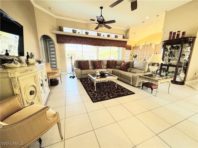 living room with light tile patterned floors, baseboards, a ceiling fan, a towering ceiling, and ornamental molding