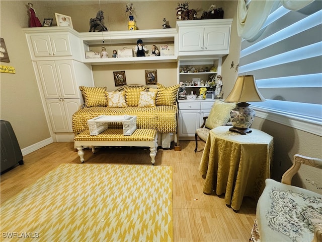 living area featuring baseboards and light wood finished floors