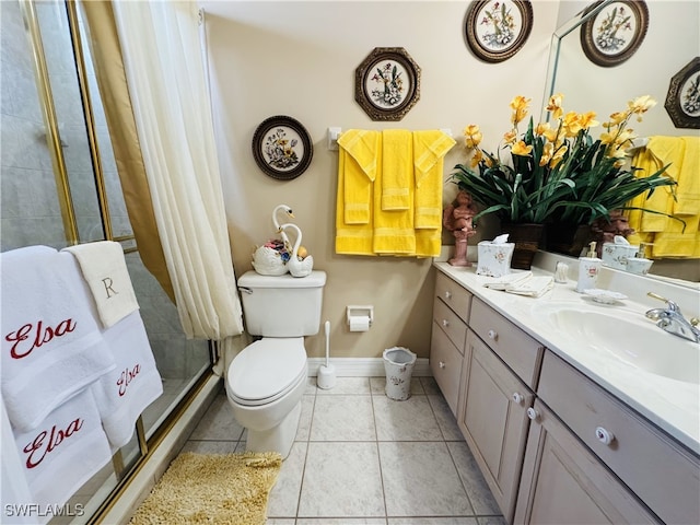 full bath featuring toilet, a stall shower, vanity, baseboards, and tile patterned floors