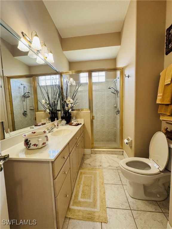 full bathroom featuring a stall shower, baseboards, vanity, and toilet