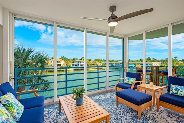 sunroom featuring ceiling fan, a water view, and a healthy amount of sunlight