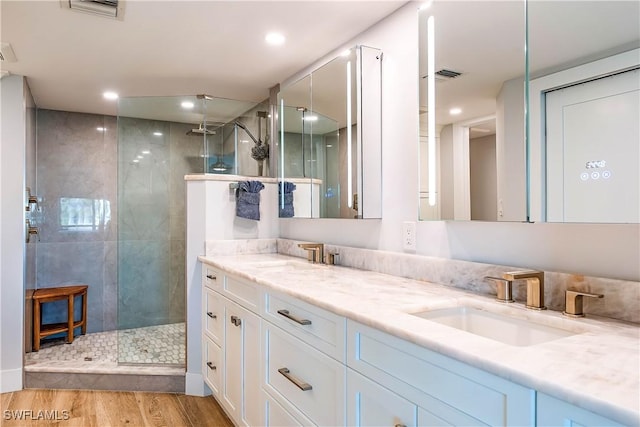 bathroom featuring a tile shower, vanity, and hardwood / wood-style flooring