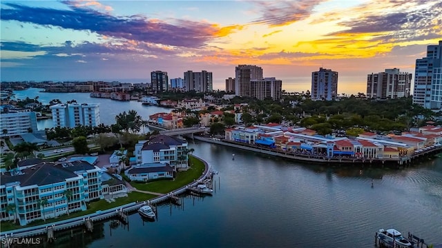 aerial view at dusk featuring a water view