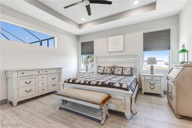 bedroom with ceiling fan and a tray ceiling