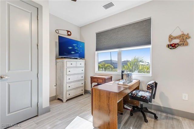 home office with light hardwood / wood-style flooring