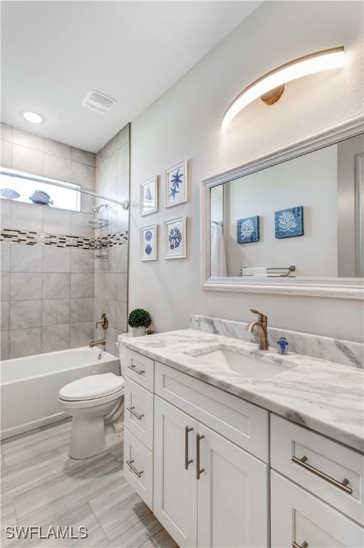 full bathroom featuring vanity, toilet, and tiled shower / bath combo