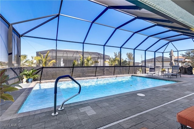 view of pool with a grill, a patio area, and a lanai