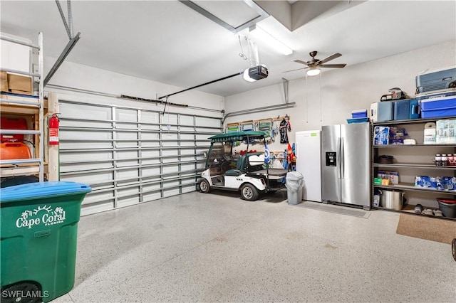 garage with stainless steel refrigerator with ice dispenser, a garage door opener, and ceiling fan