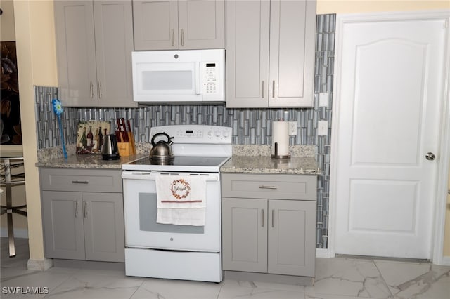 kitchen with backsplash, light stone counters, and white appliances