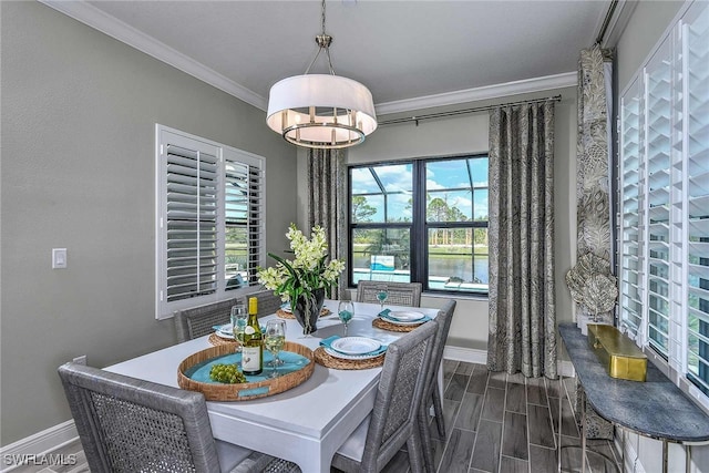 dining area featuring crown molding and a water view