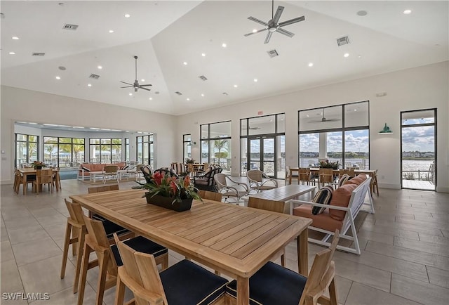 dining space with high vaulted ceiling and ceiling fan