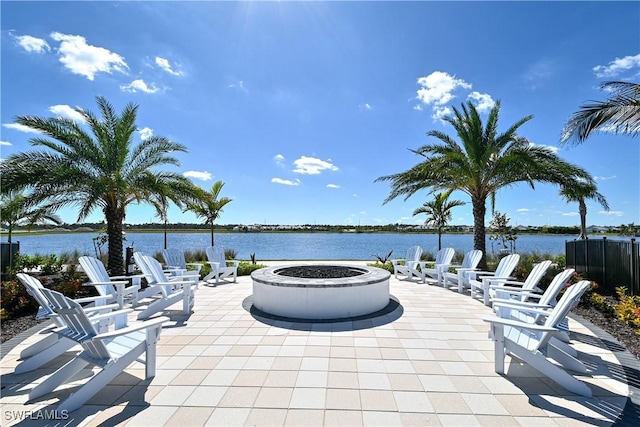 view of patio with a fire pit and a water view