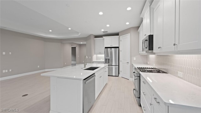 4096 Pegasus Way, Naples, FL 34120 - kitchen with stainless steel appliances, a sink, light wood finished floors, decorative backsplash, and a kitchen island with sink