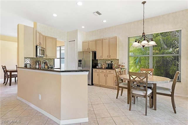 kitchen featuring decorative backsplash, stainless steel appliances, light tile patterned floors, decorative light fixtures, and a notable chandelier