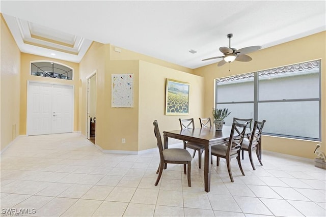 dining room featuring light tile patterned floors, a tray ceiling, ceiling fan, and crown molding