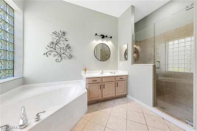 bathroom featuring shower with separate bathtub, vanity, and tile patterned floors