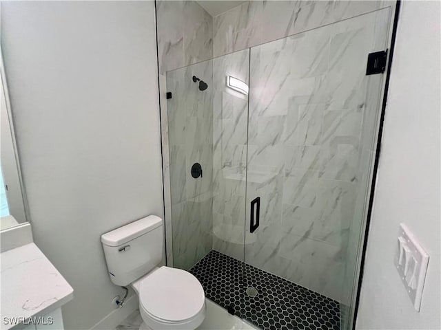 bathroom featuring a shower with door, vanity, and toilet