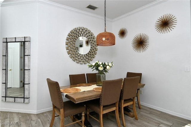 dining area with crown molding and wood-type flooring