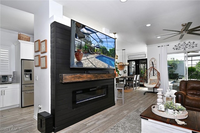 living room featuring crown molding, a large fireplace, and ceiling fan