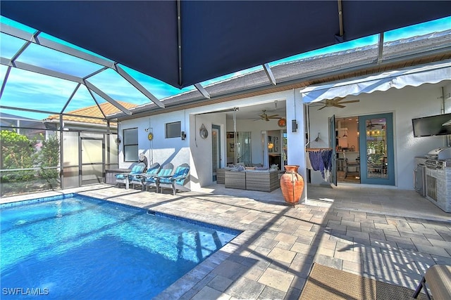 view of pool with a patio, an outdoor hangout area, ceiling fan, and glass enclosure