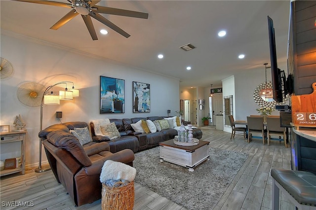 living room with crown molding and ceiling fan