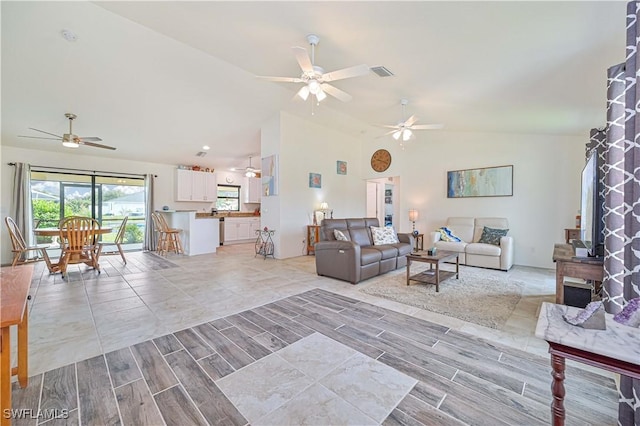 living room featuring ceiling fan, a wealth of natural light, and vaulted ceiling