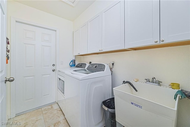 washroom with washing machine and dryer, cabinets, light tile patterned floors, and sink