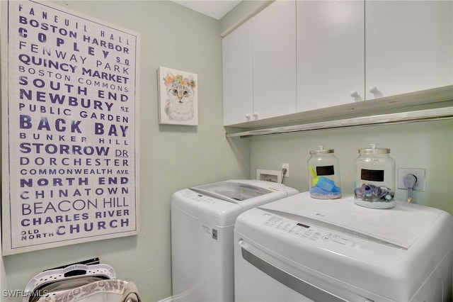 laundry room featuring washing machine and dryer and cabinets