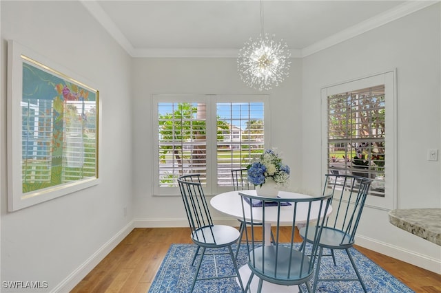 dining space featuring hardwood / wood-style floors, crown molding, and a chandelier