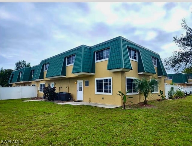 rear view of property with a patio area, a yard, and central air condition unit