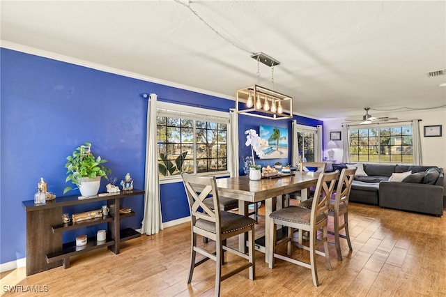 dining area with visible vents, crown molding, ceiling fan, and wood finished floors