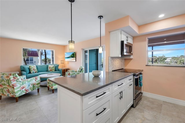 kitchen featuring tasteful backsplash, hanging light fixtures, white cabinets, and stainless steel appliances