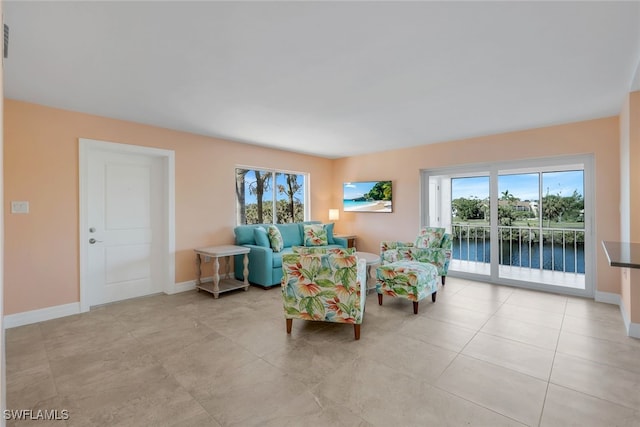 living room with light tile patterned floors and a water view