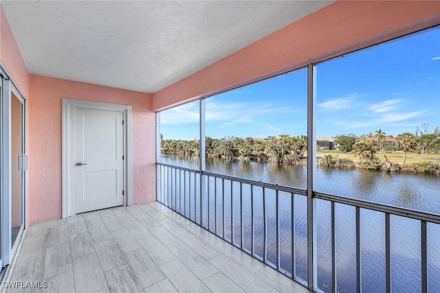 unfurnished sunroom featuring a water view