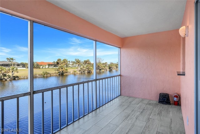 unfurnished sunroom featuring a water view